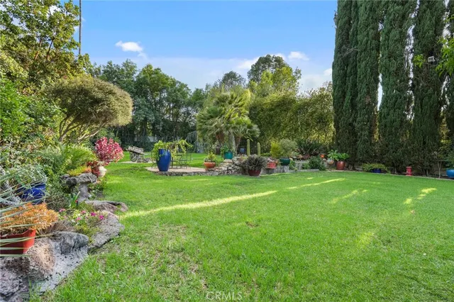 an aerial view of residential houses with outdoor space and trees