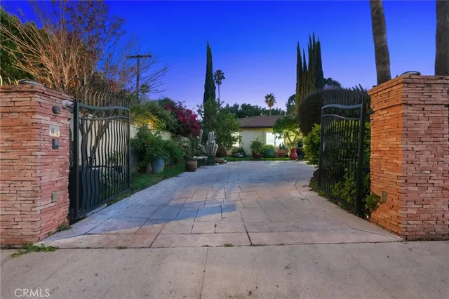 a view of a house with a yard and potted plants