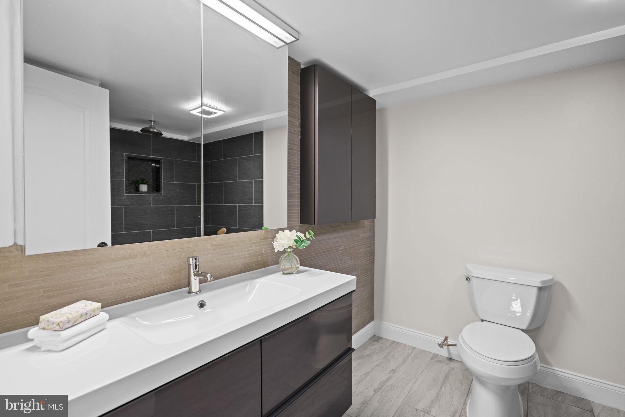 4900 Montgomery Avenue Bethesda, MD 20816 - Photo 46 of 57 a bathroom with a toilet sink double vanity and mirror