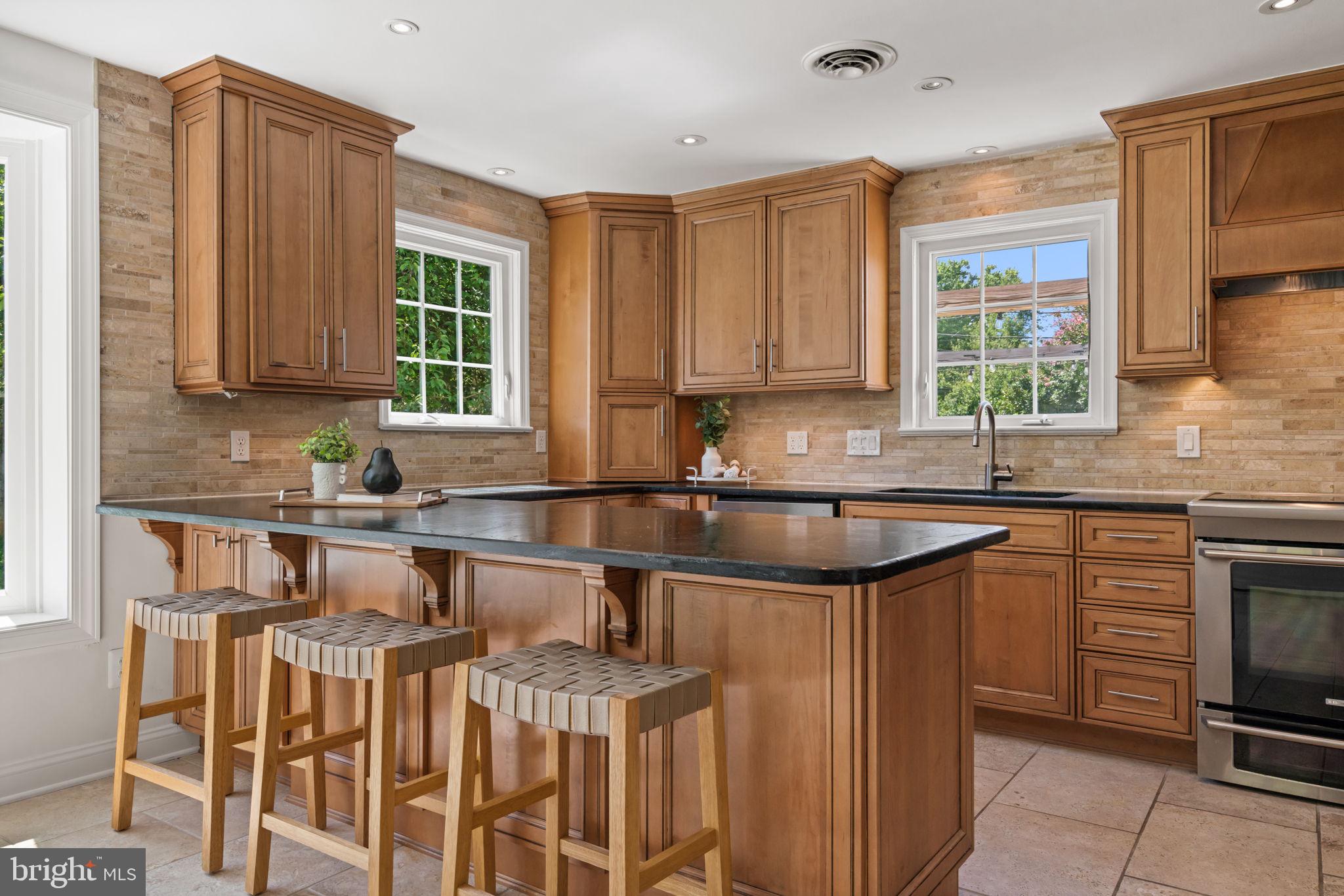 4900 Montgomery Avenue Bethesda, MD 20816 - Photo 9 of 57 a kitchen with stainless steel appliances granite countertop a sink stove and cabinets