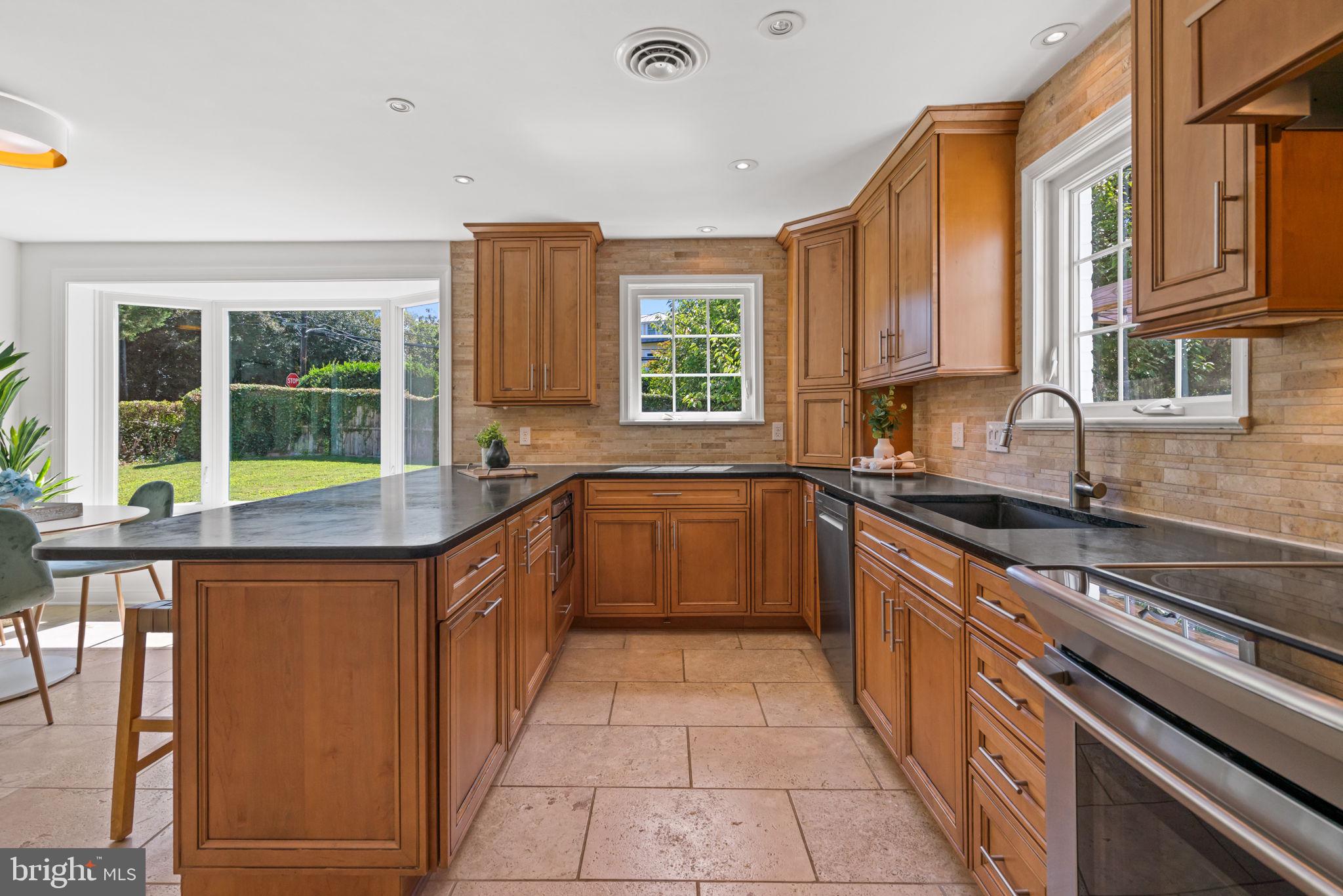 4900 Montgomery Avenue Bethesda, MD 20816 - Photo 10 of 57 a kitchen with stainless steel appliances granite countertop a sink and a stove