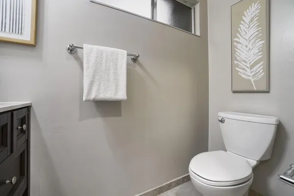 a white toilet sitting next to a white wall
