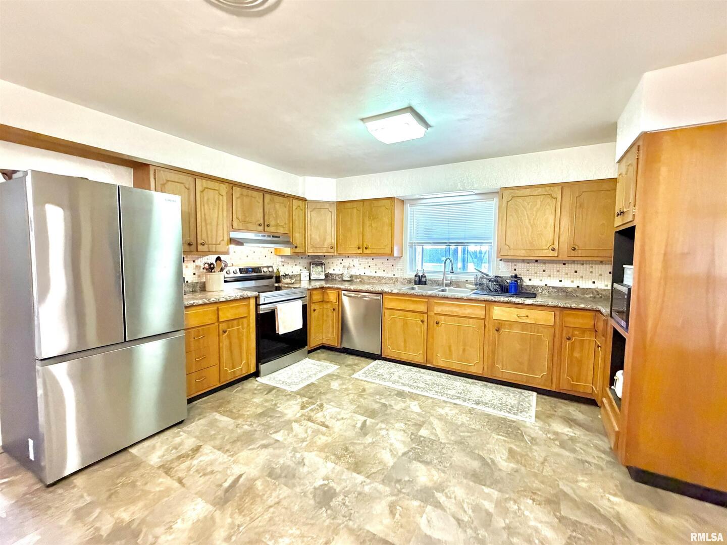315 Hosselton Street Southwest Clay City, IL 62824 - Photo 19 of 70 a kitchen with granite countertop a refrigerator and a stove top oven