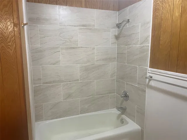 an empty room with chandelier fan and windows