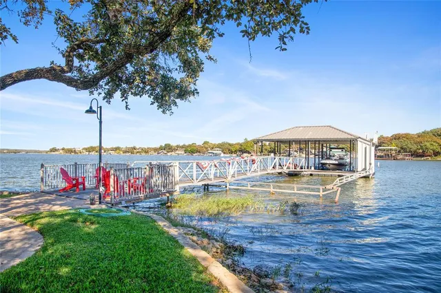 an aerial view of a house with swimming pool a yard and lake view
