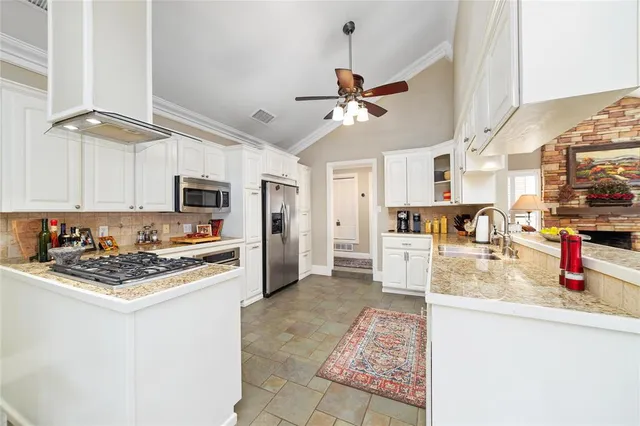 a kitchen with stainless steel appliances granite countertop a sink dishwasher stove refrigerator and cabinets