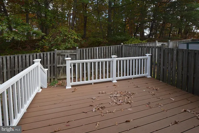 a view of deck and yard with wooden fence