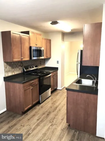 a kitchen with stainless steel appliances granite countertop a sink stove and microwave