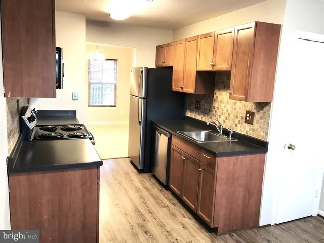 a kitchen with kitchen island granite countertop a sink stove and refrigerator