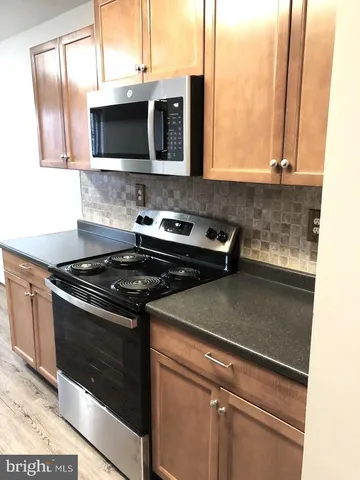 a kitchen with stainless steel appliances a stove a microwave and sink