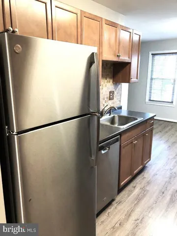 a kitchen with stainless steel appliances granite countertop a refrigerator a sink a stove and a refrigerator