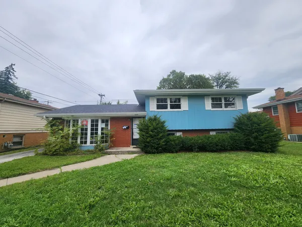 a front view of a house with a yard and green space