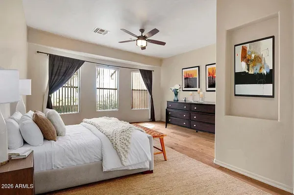 a bedroom with a bed dresser and a flat tv screen