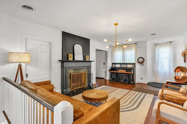 a dining room with furniture a chandelier and wooden floor
