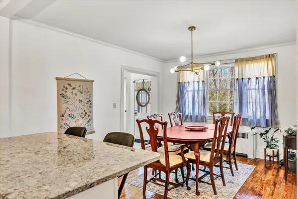 a dining room with furniture a chandelier and wooden floor