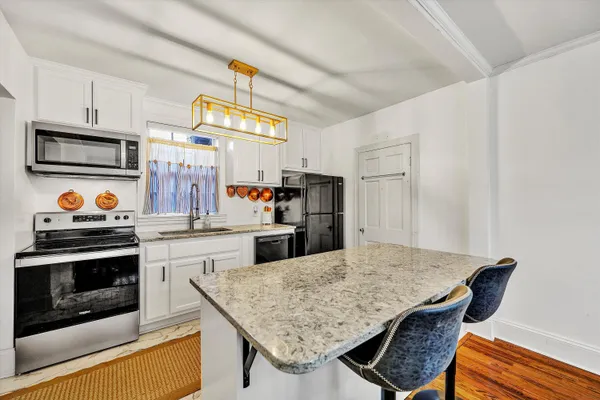 a kitchen with stainless steel appliances granite countertop a refrigerator and a stove top oven