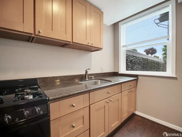 a kitchen with granite countertop white cabinets and black appliances