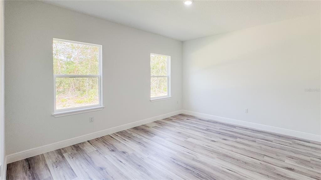 15625 Southwest 37th Circle Ocala, FL 34473 - Photo 22 of 27 an empty room with wooden floor and windows