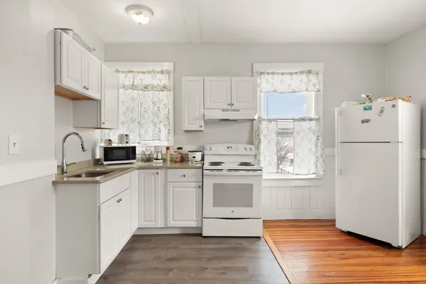 a kitchen with white cabinets and white appliances
