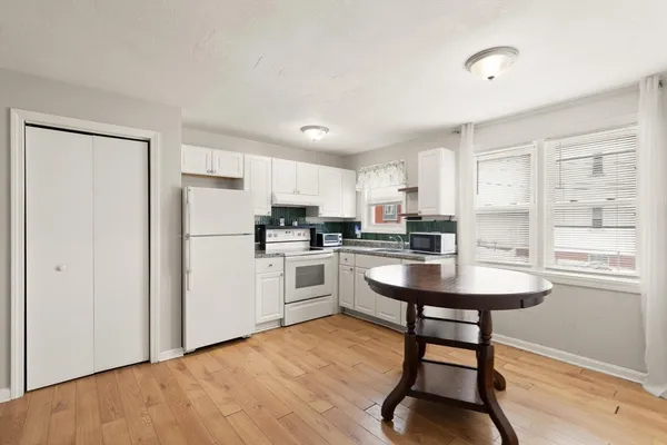 a kitchen with white cabinets and white appliances