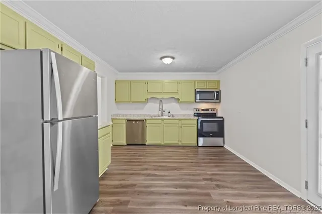 a kitchen with refrigerator cabinets and wooden floor