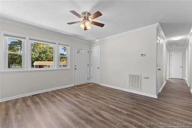 a view of empty room with wooden floor and window