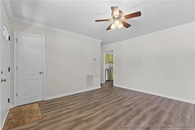 a view of an empty room with wooden floor