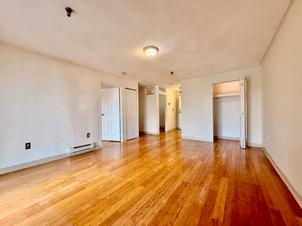 a view of an empty room with wooden floor