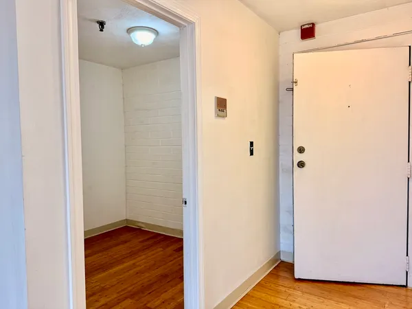 a view of a hallway with wooden floor