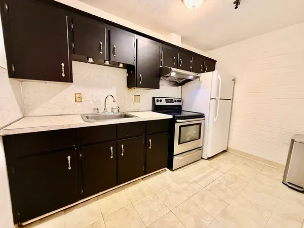 a kitchen with stainless steel appliances a sink and a refrigerator
