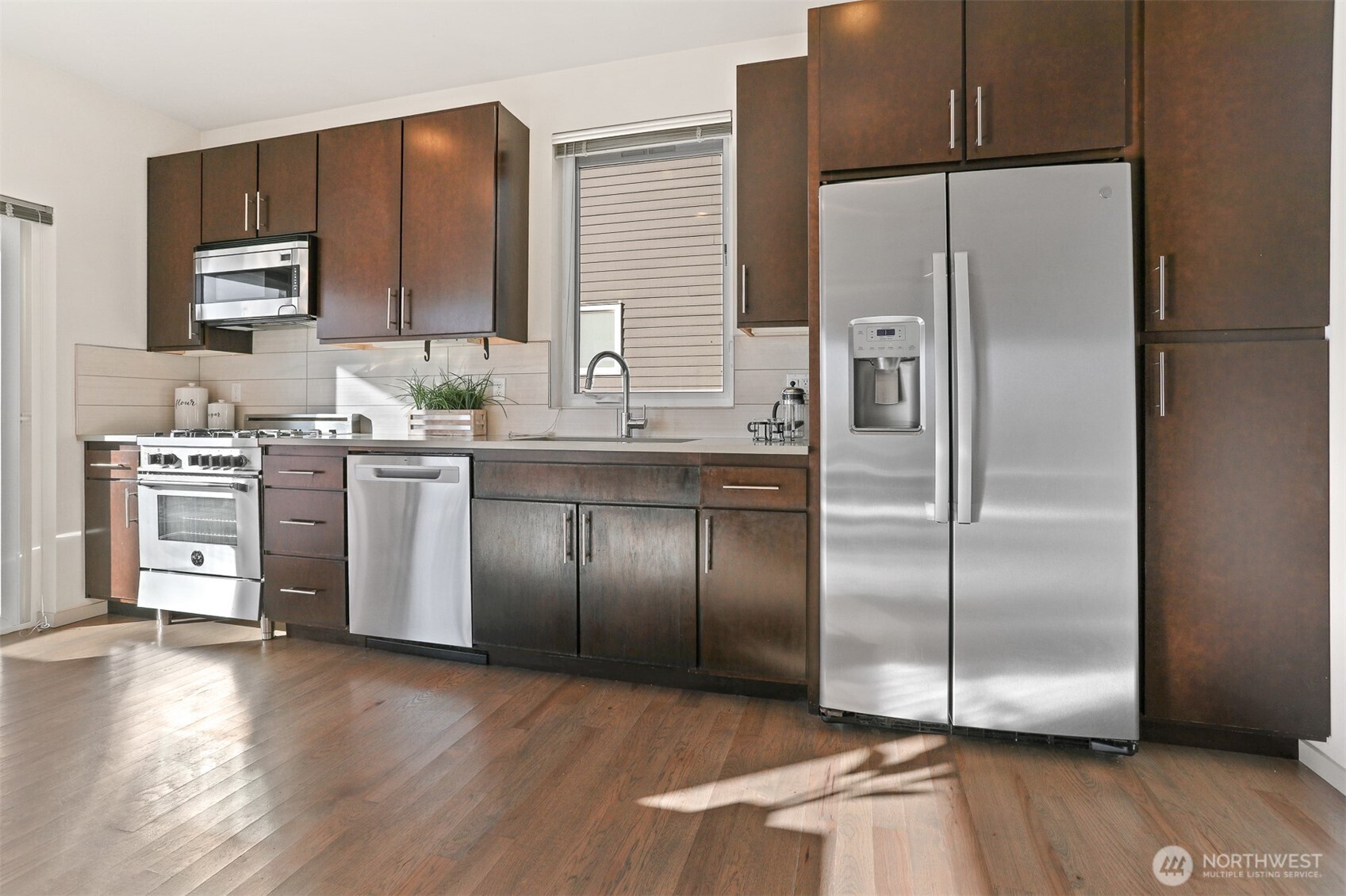 2426B Northwest 64th Street Seattle, WA 98107 - Photo 13 of 38 a kitchen with stainless steel appliances granite countertop a refrigerator a sink a stove and oven