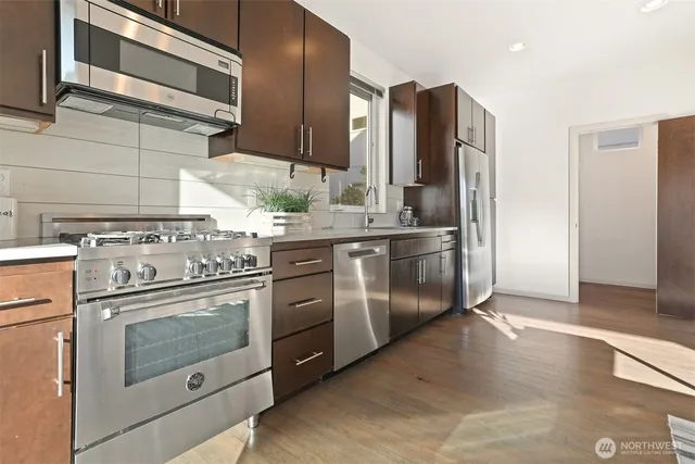 a kitchen with stainless steel appliances granite countertop a stove a refrigerator and a microwave