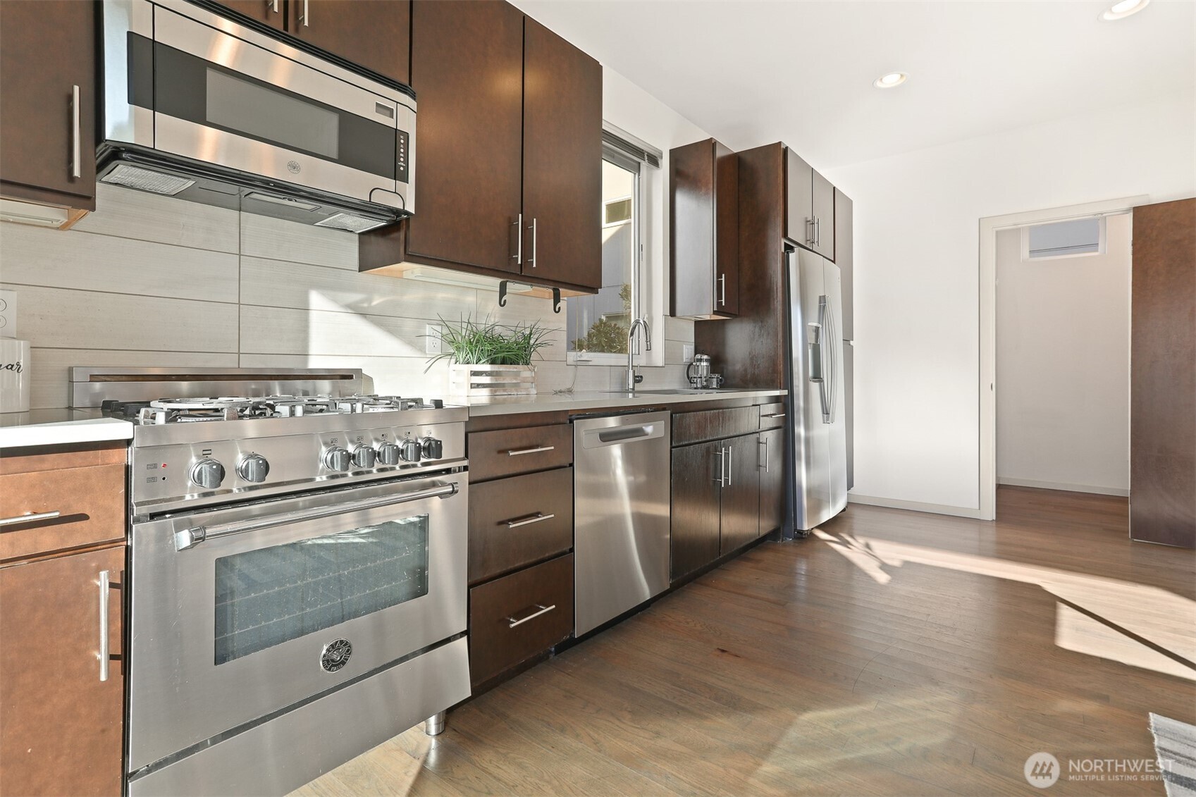 2426B Northwest 64th Street Seattle, WA 98107 - Photo 14 of 38 a kitchen with stainless steel appliances granite countertop a stove a refrigerator and a microwave
