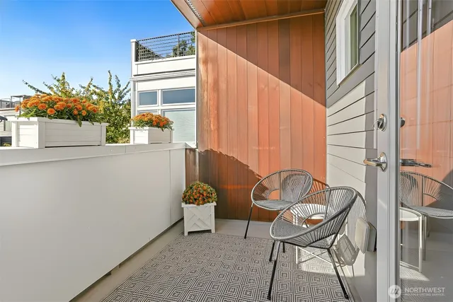 a backyard of a house with table and chairs potted plants