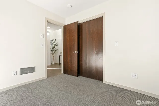 an empty room with closet and mirror