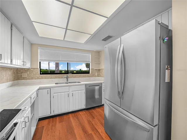 a kitchen with stainless steel appliances granite countertop a refrigerator and a sink