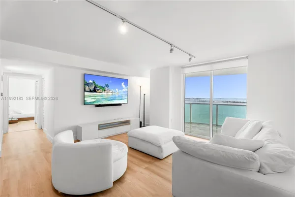 a living room with furniture a large window and a flat screen tv