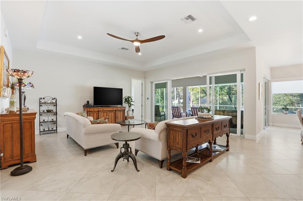 3707 5th Avenue Southwest Naples, FL 34117 - Photo 10 of 48 Living area featuring a ceiling fan, a raised ceiling, recessed lighting, and light tile patterned floors
