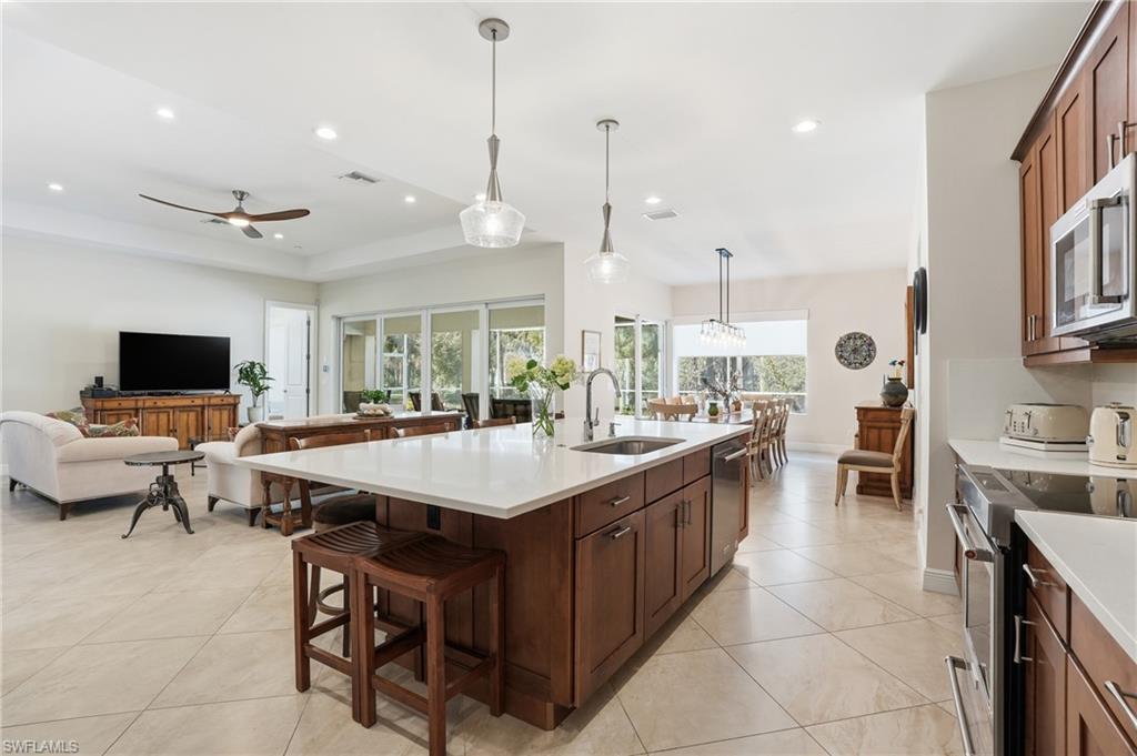 3707 5th Avenue Southwest Naples, FL 34117 - Photo 48 of 48 Kitchen with a breakfast bar area, hanging light fixtures, open floor plan, stainless steel appliances, and a large island with sink