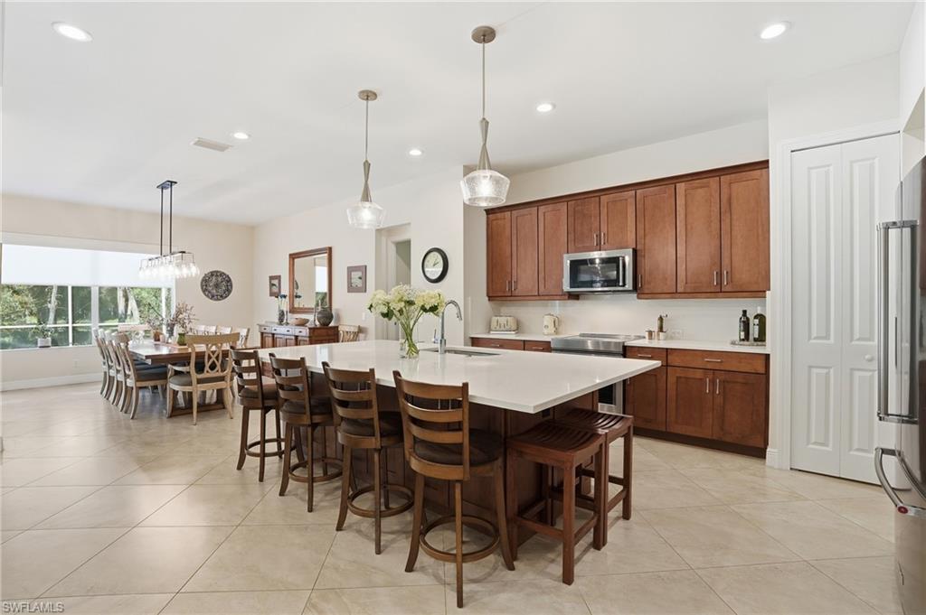 3707 5th Avenue Southwest Naples, FL 34117 - Photo 3 of 48 Kitchen with pendant lighting, a kitchen island with sink, a kitchen breakfast bar, recessed lighting, and appliances with stainless steel finishes