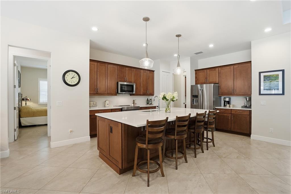 3707 5th Avenue Southwest Naples, FL 34117 - Photo 4 of 48 Kitchen featuring a kitchen bar, decorative light fixtures, an island with sink, appliances with stainless steel finishes, and recessed lighting