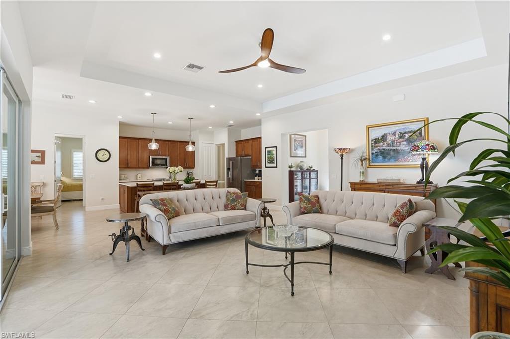 3707 5th Avenue Southwest Naples, FL 34117 - Photo 9 of 48 Living room featuring ceiling fan, a tray ceiling, recessed lighting, and light tile patterned floors
