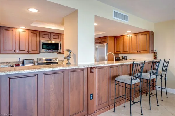 a kitchen with stainless steel appliances granite countertop a sink a stove and cabinets
