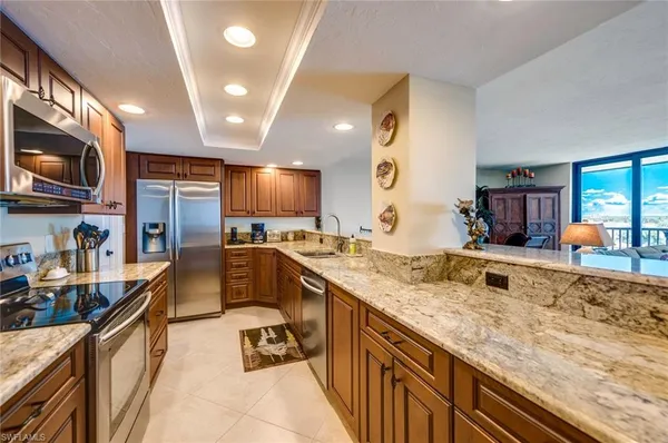 a kitchen with stainless steel appliances granite countertop a sink a stove cabinets and refrigerator