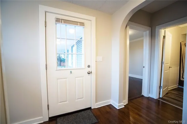 an empty room with wooden floor cabinet and windows