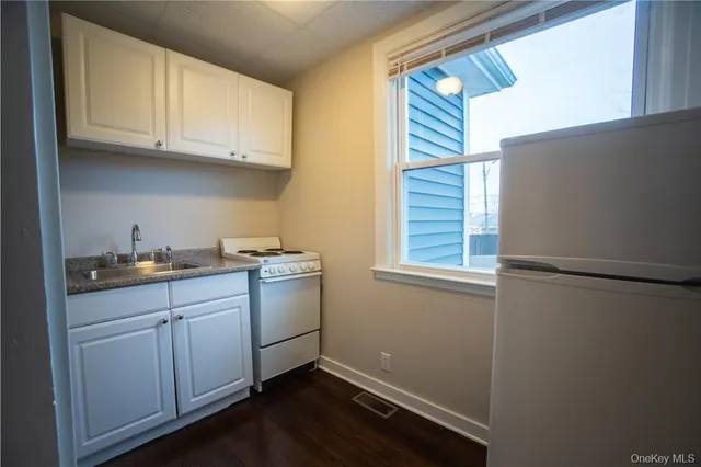 a kitchen with a sink cabinets and a window