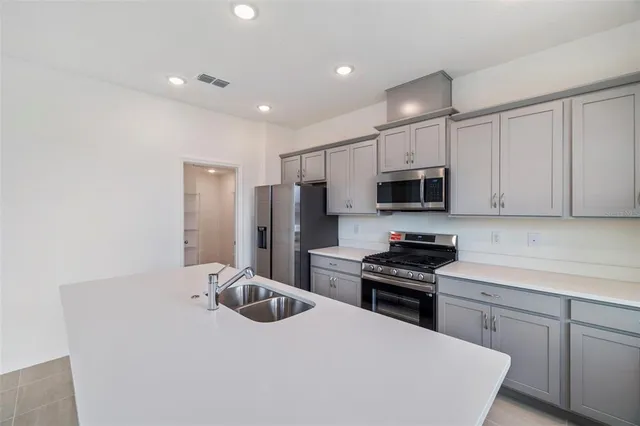 a kitchen with stainless steel appliances a refrigerator stove microwave and sink