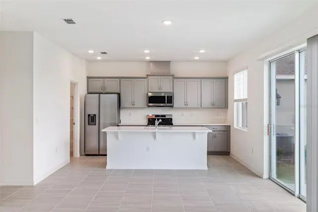 a kitchen with stainless steel appliances a refrigerator sink and microwave