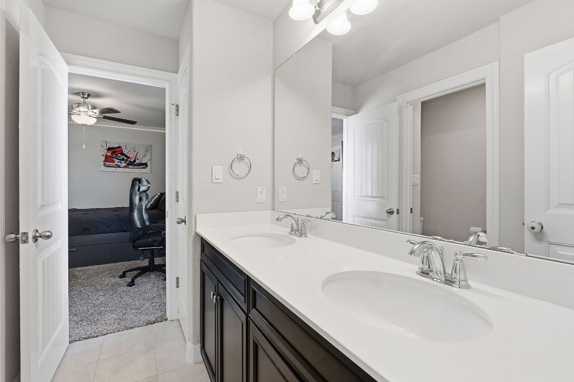 15604 Cabrillo Way Austin, TX 78738 - Photo 12 of 33 a en suite bathroom with a double vanity sink a mirror and a shower