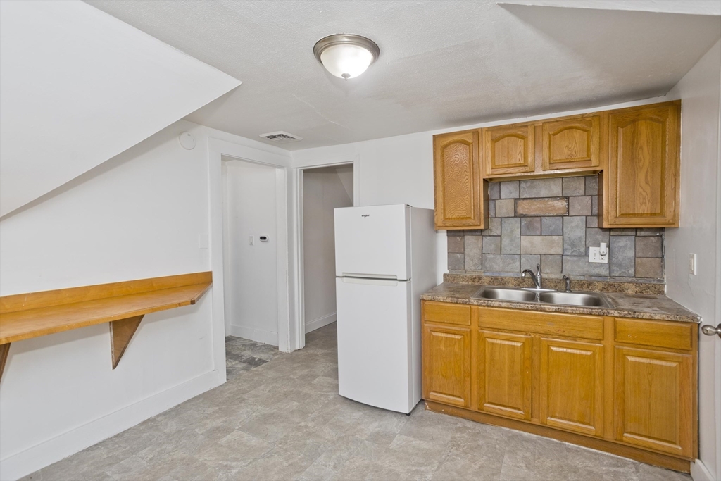 202 Oakland Street Springfield, MA 01108 - Photo 24 of 39 a kitchen with a sink and refrigerator
